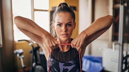 Eine Frau trainiert ihre Arme mit einem Powerband Eine Frau trainiert ihre Arme mit einem Powerband