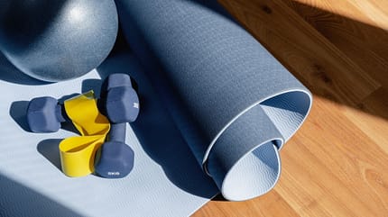 Eine Yogamatte, Powerband und Kurzhanteln Eine Yogamatte, Powerband und Kurzhanteln