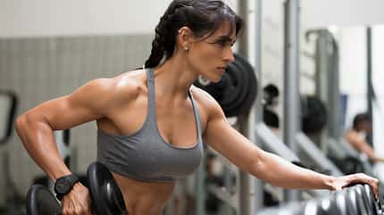 Eine starke Frau trainiert ihre Oberarme mit Kurzhanteln