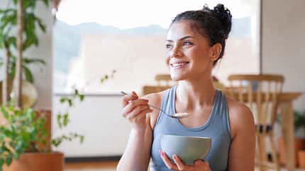 Healthy woman eating a parfait for breakfast at home Healthy woman eating a parfait for breakfast at home