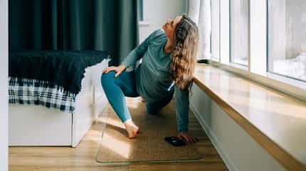 Eine Frau macht Yoga auf einer Matte Eine Frau macht Yoga auf einer Matte