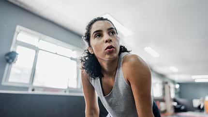 Tired mid adult woman at gym