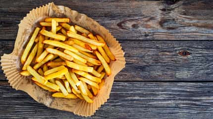 Pommes auf einem Backpapier speziell für die Heißluftfritteuse Pommes auf einem Backpapier speziell für die Heißluftfritteuse