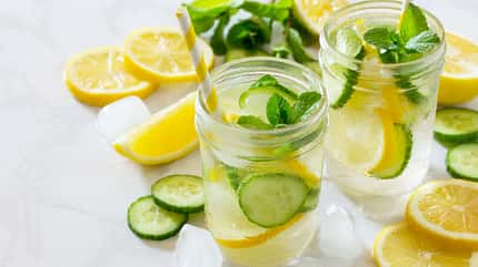 Infused Water mit Zitrone, Gurke und Minze im Glas Infused Water mit Zitrone, Gurke und Minze im Glas