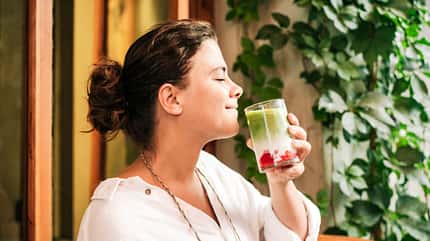 Eine Frau trinkt einen Iced Strawberry Matcha Latte Eine Frau trinkt einen Iced Strawberry Matcha Latte