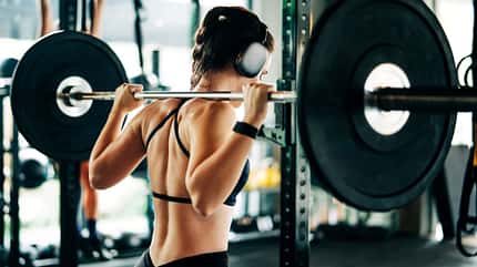 Eine Frau macht Krafttraining im Gym mit einer Langhantel Eine Frau macht Krafttraining im Gym mit einer Langhantel