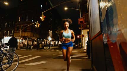 Eine Frau joggt bei Nacht durch die Stadt