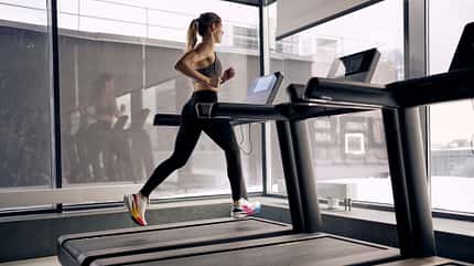 Eine Frau läuft im Fitnessstudio auf dem Laufband Eine Frau läuft im Fitnessstudio auf dem Laufband