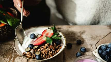 Eine Frau isst einen griechischen Joghurt Eine Frau isst einen griechischen Joghurt