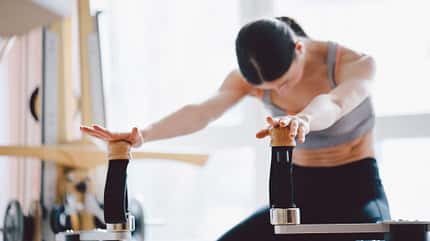 Eine Frau trainiert an einem Stretching-Gerät in einem Fitnessstudio