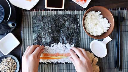 Reis, Fisch und sonstige Zutaten aufs Noriblatt legen Reis, Fisch und sonstige Zutaten aufs Noriblatt legen