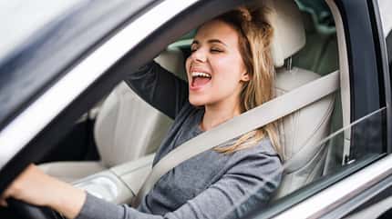 Frau singt im Auto