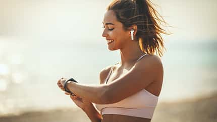 A,Beautiful,Young,Woman,Is,Looking,At,Smartwatch,And,Preparing