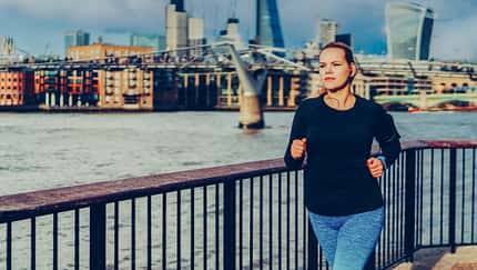 Junge Läuferin, die an einem Fluss joggt