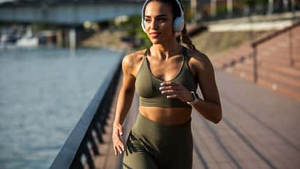 Young and happy active female athlete running outdoor