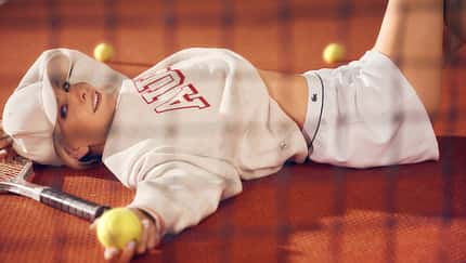 Janin Ullmann liegt mit Ball und Schläger vor einem Tennisnetz