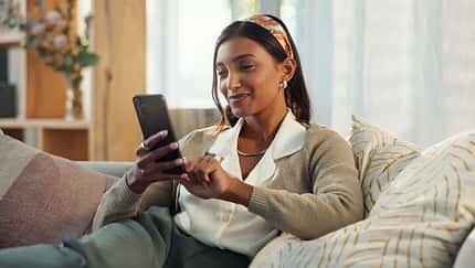 Cellphone,,Indian,Woman,And,Smile,On,Sofa,In,Home,In
