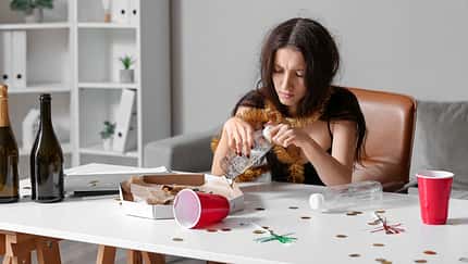 Young,Woman,With,Hungover,Drinking,Water,At,Table,In,Office