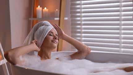 Glückliche Frau in der Badewanne