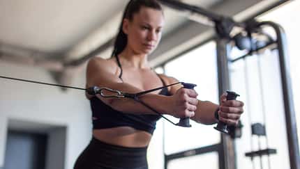 Fit,Young,Woman,Doing,Cable,Pec,Fly,Exercise,In,Gym,