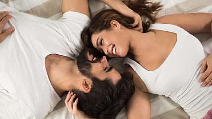 High,Angle,View,Of,Smiling,Couple,Relaxing,And,Lying,Down