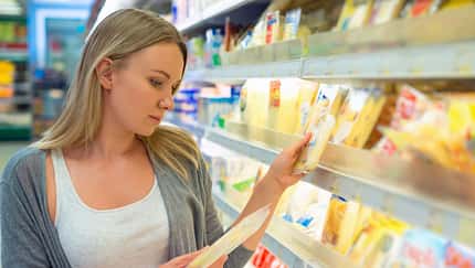 Woman,Choosing,Cheese,In,Grocery,Store.