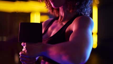Eine trainierte junge Frau führt ein Workout mit einer Hantel durch