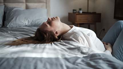 Emotional exhaustion. Tired exhausted young woman lying on bed feeling depressed