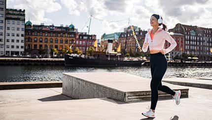 Junge Sportlerin, die in Malmö, Schweden, läuft und die Stadtlandschaft genießt