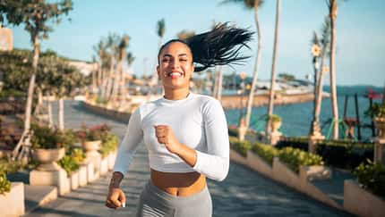 Junge Frau joggt am Wasser