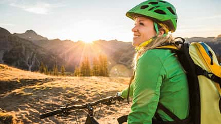 Frau mit Mountainbike in der Sonne