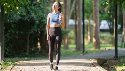 Young,Asian,Woman,,Dressed,In,Sportswear,,Walks,Along,A,Park