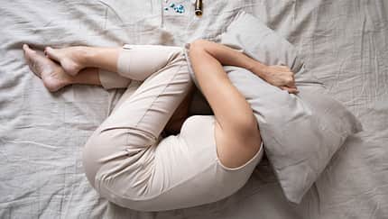 Depressed,Mature,Woman,Lying,In,Bed,With,Bottle,Of,Pills