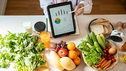 frisches Obst und ein Tablet mit einem Ernährungsplan