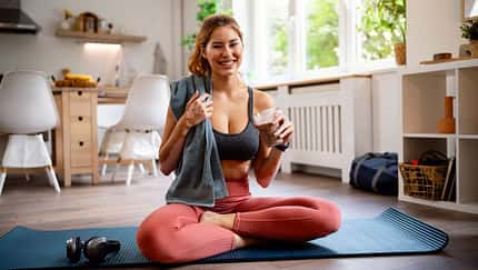 Portrait einer Frau in Sportkleidung auf einer Fitnessmatte