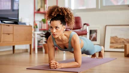 Eine Frau macht Planks auf einer Yogamatte