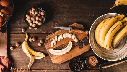 Eine aufgeschnittene Banane und Schokolade auf einem Brett