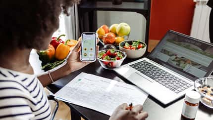 Eine Frau erstellt einen Ernährungsplan am Laptop Eine Frau erstellt einen Ernährungsplan am Laptop