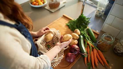 Eine Frau packt Bio-Lebensmittel in einen Beutel Eine Frau packt Bio-Lebensmittel in einen Beutel
