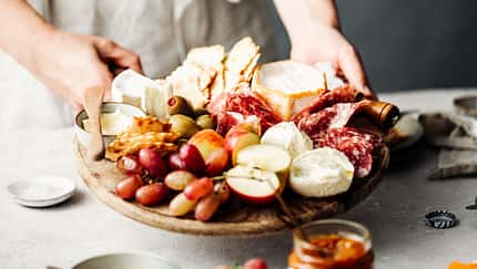 Eine Frau serviert eine Mezze-Platte auf einem Tisch