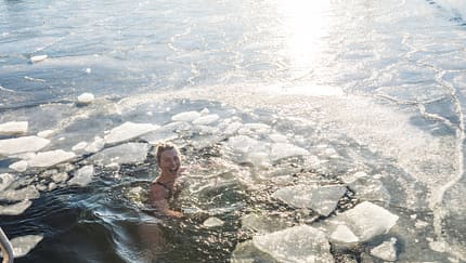 Happy Woman Treading Water With Ice In The Ocean In Denmark