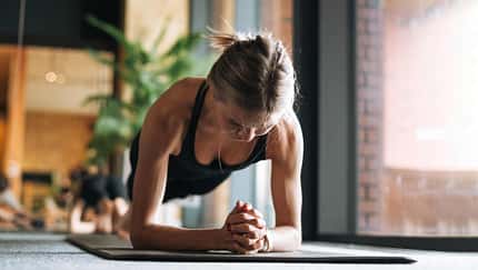 Frau macht Plank-Übung auf einer Sportmatte