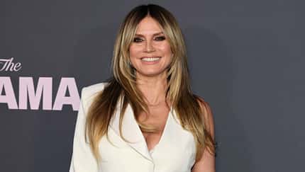Heidi Klum lächelt im Weißen Kleid in die Kamera Heidi Klum lächelt im Weißen Kleid in die Kamera