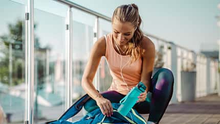 Eine Frau in Sportkleidung packt ihre Sporttasche Eine Frau in Sportkleidung packt ihre Sporttasche