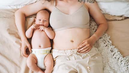 Frau liegt mit ihrem Baby im Bett Frau liegt mit ihrem Baby im Bett