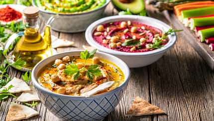 Hummus Three bowl of chickpeas, avocado and beetroot vegetables for dip on rustic wooden table Hummus Three bowl of chickpeas, avocado and beetroot vegetables for dip on rustic wooden table