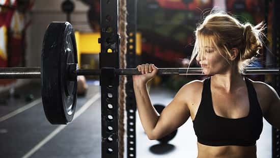Frau an einer Langhantel am Rack