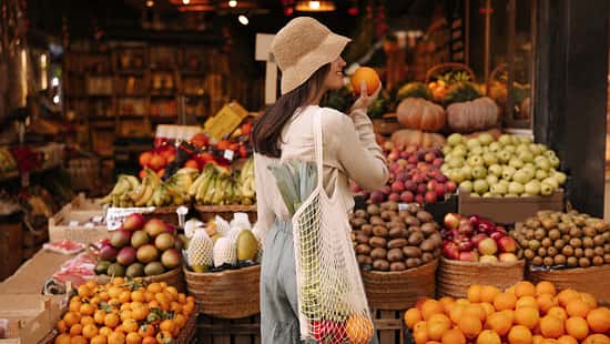 Fair-skinned,Young,Girl,Holds,Orange,Standing,With,Her,Back,To