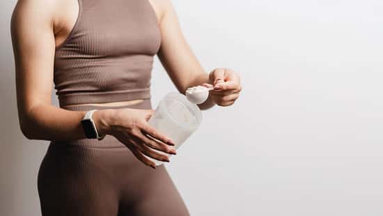Eine Frau in Sportkleidung mit Shaker