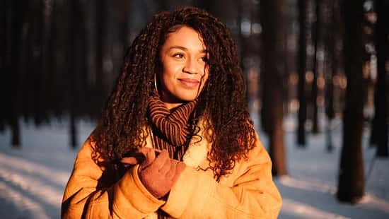 Eine Frau in Winterkleidung im winterlichen Wald